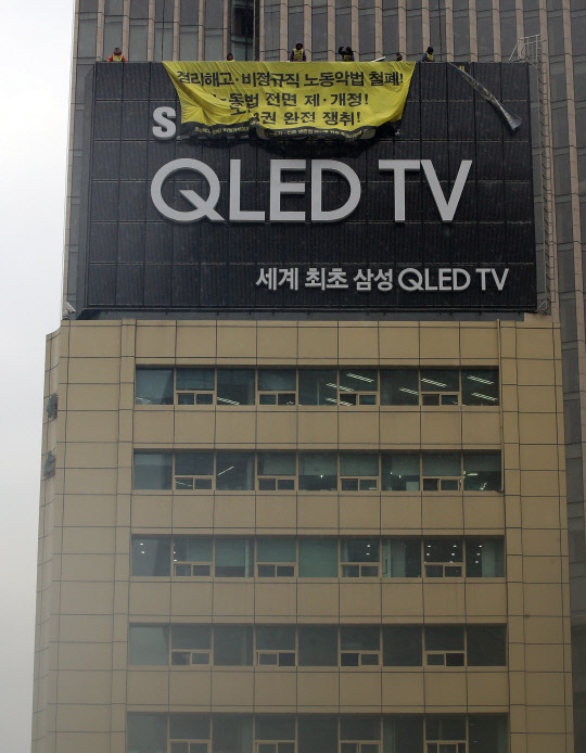 14일 오후 서울 광화문 사거리의 한 광고탑에서 노동자ㆍ민중생존권 쟁취를 위한 투쟁사업장 공동투쟁위원회 관계자들이 고공 단식농성 돌입 기자회견을 열고 정리해고 철폐, 비정규직 철폐, 노동3권 보장을 요구하며 구호를 외치고 있다.